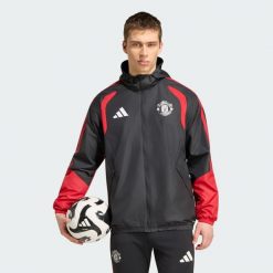 Kurtka Manchester United 26/27 Tiro All Weather. Czarne kurtki sportowe męskie Adidas, m, bez wzorów, z materiału, na fitness i siłownię. Za 429.50 zł.