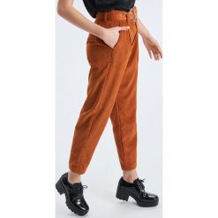 Sztruksowe spodnie o kroju carrot - Brązowy. Spodnie materiałowe damskie marki Cropp. Za 99.99 zł.
