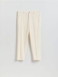 Garniturowe spodnie carrot - biały. Białe eleganckie spodnie męskie Reserved, bez wzorów, z tkaniny. Za 169.99 zł.