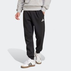 Second Life - Spodnie dresowe męskie ADIDAS Essentials Feelcozy - Stan Dobry. Czarne spodnie sportowe męskie Adidas, m, bez wzorów, z bawełny, na fitness i siłownię. Za 164.99 zł.