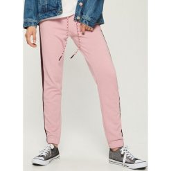 Spodnie dresowe z lampasami - Różowy. Czerwone spodnie dresowe damskie Sinsay, z dresówki. Za 49.99 zł.