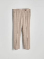 Spodnie garniturowe slim fit - beżowy. Brązowe eleganckie spodnie męskie Reserved, bez wzorów, z tkaniny. W wyprzedaży za 129.99 zł.