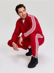 Sportowe spodnie z kontrastowymi lampasami - czerwony. Czerwone spodnie sportowe męskie Sinsay, l, bez wzorów, na fitness i siłownię. Za 59.99 zł.