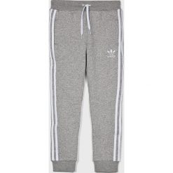 Adidas Originals - Spodnie dziecięce 128-164 cm. Szare spodnie materiałowe dla chłopców adidas Originals, bez wzorów, z bawełny. W wyprzedaży za 139.90 zł.