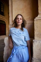 Bawełniana bluzka z aplikacją błękitna. Niebieskie bluzki damskie MOODO, l, z aplikacjami, z bawełny, bez kołnierzyka, bez ramiączek. Za 59.99 zł.