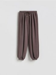 Spodnie balloon - brązowy. Brązowe spodnie materiałowe damskie Reserved, l, bez wzorów, z dzianiny. Za 99.99 zł.