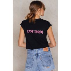 Josefin Ekström for NA-KD T-shirt Easy Tiger - Black. Czarne t-shirty damskie marki Josefin Ekström for NA-KD, bez wzorów, z bawełny, bez kołnierzyka. W wyprzedaży za 40.47 zł.