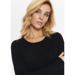SWETER Z OZDOBNYMI KAMYCZKAMI Z PRZODU. Czarne swetry damskie TOP SECRET, na jesień, bez wzorów, bez kołnierzyka, bez ramiączek, bez kaptura. W wyprzedaży za 39.99 zł.