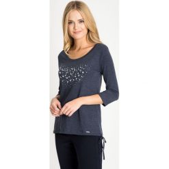 Melanżowa granatowa bluzka z wiązaniem u dołu QUIOSQUE. Białe bluzki damskie marki QUIOSQUE, z jeansu. W wyprzedaży za 39.99 zł.
