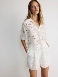 Koronkowa bluzka z bawełny - złamana biel. Bluzki damskie Reserved, l, bez wzorów, z bawełny, bez kołnierzyka, bez ramiączek. W wyprzedaży za 139.99 zł.