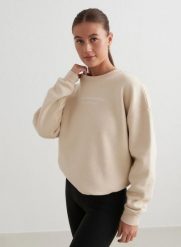 Damska bluza dresowa czesana, luźny krój Serif kawa z mlekiem. Białe bluzy damskie Aim'n, s, bez wzorów, z bawełny, bez kaptura, na fitness i siłownię. Za 219.70 zł.