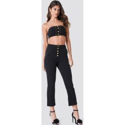 Galore x NA-KD Spodnie ze złotymi detalami - Black. Czarne spodnie materiałowe damskie marki Galore x NA-KD. Za 202.95 zł.