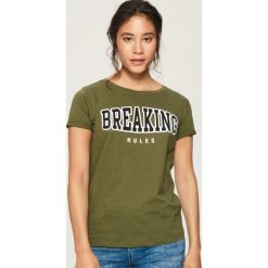 T-shirt z napisem - Khaki. T-shirty damskie marki DOMYOS. Za 19.99 zł.