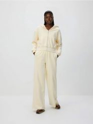 Spodnie dresowe z szerokimi nogawkami - kremowy. Białe spodnie dresowe damskie Reserved, l, bez wzorów, z bawełny. Za 89.99 zł.