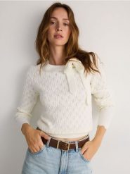 Ażurowy sweter z wiązaniem - złamana biel. Swetry damskie Reserved, l, w ażurowe wzory, z dzianiny, bez kołnierzyka, bez ramiączek, bez kaptura. W wyprzedaży za 79.99 zł.