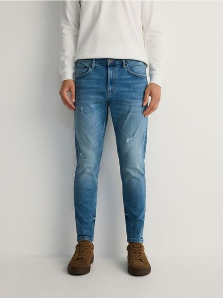 Jeansy carrot slim z przetarciami - niebieski. Niebieskie jeansy męskie Reserved. W wyprzedaży za 99.99 zł.