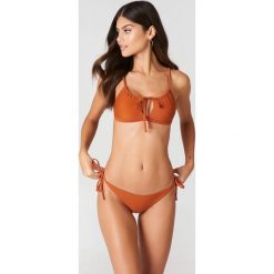 J&K Swim X NA-KD Dół bikini z wiązaniem w talii Triangle - Orange. Bikini damskie marki J&K Swim X NA-KD. W wyprzedaży za 36.47 zł.