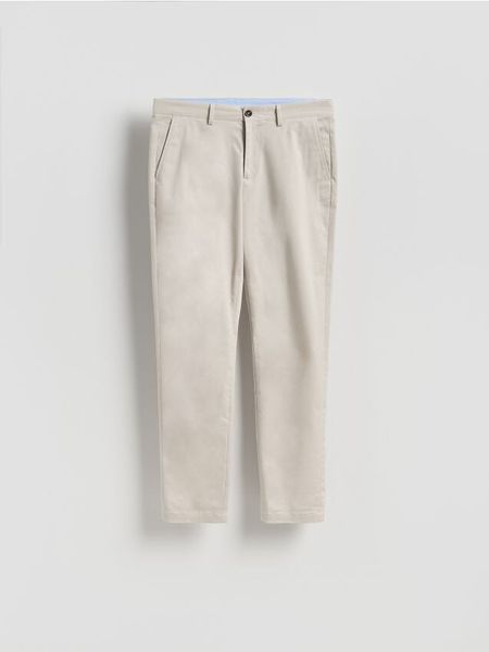 Bawełniane spodnie chino slim - jasnoszary. Szare spodnie materiałowe męskie Reserved, bez wzorów, z bawełny. Za 149.99 zł.
