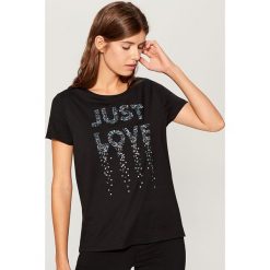 Koszulka z błyszczącą aplikacją - Czarny. Czarne t-shirty damskie Mohito, z aplikacjami. W wyprzedaży za 39.99 zł.