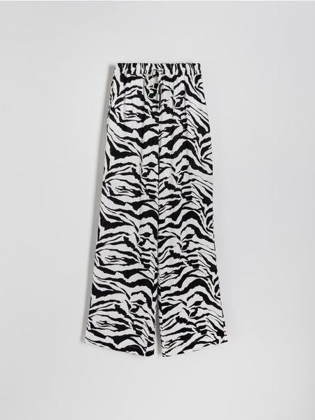 Spodnie palazzo z nadrukiem - czarny. Czarne spodnie materiałowe damskie Reserved, l, bez wzorów, z tkaniny. W wyprzedaży za 49.99 zł.